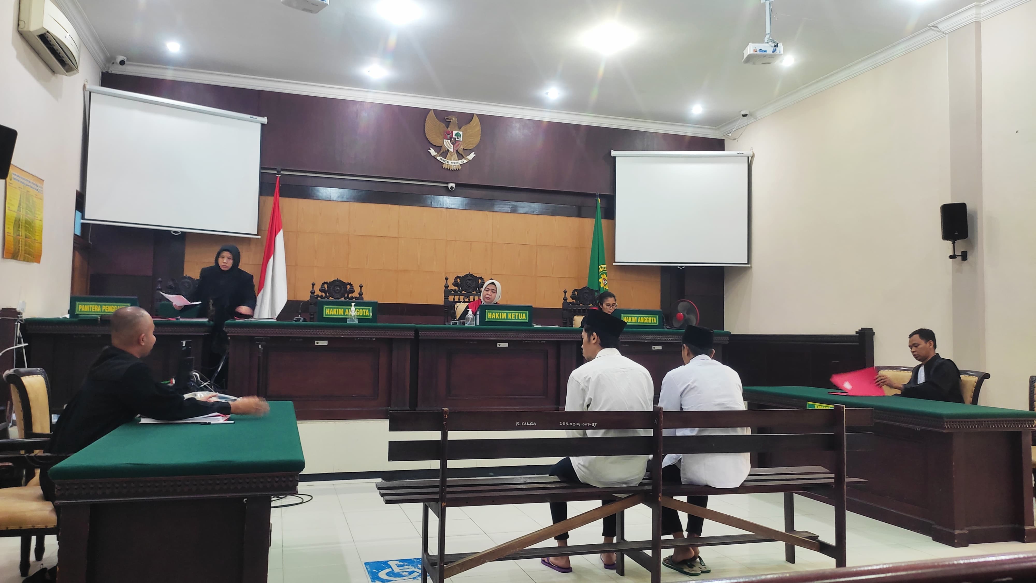 PESAKITAN: Kedua terdakwa kasus pembunuhan berencana menghadapi sidang putusan di Pengadilan Negeri Mojokerto, Kamis (7/12).