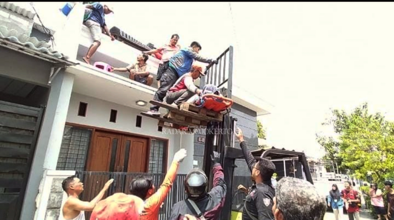 DRAMATIS: Suliyanto dievakuasi petugas PMI dan relawan menggunakan forklift usai ditemukan pingsan diatap rumahnya kemarin.