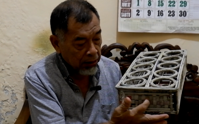 KREATIF: Budiman Sudijono, pensiunan PNS menunjukkan tempat air mineral hasil daur ulang koran bekas di rumahnya, Kelurahan Wates, Kota Mojokerto. (foto Misbakhul Ulum for JPRM)