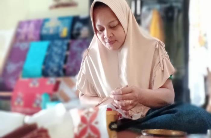 KREATIF: Yuliarni, perajin batik motif Candi Wringin Lawang, sedang mencanting batik di rumahnya, di Dusun Wringin Lawang, Desa Jatipasar, Kecamatan Trowulan. (foto Nadya Azzahra for Radar Mojokerto)