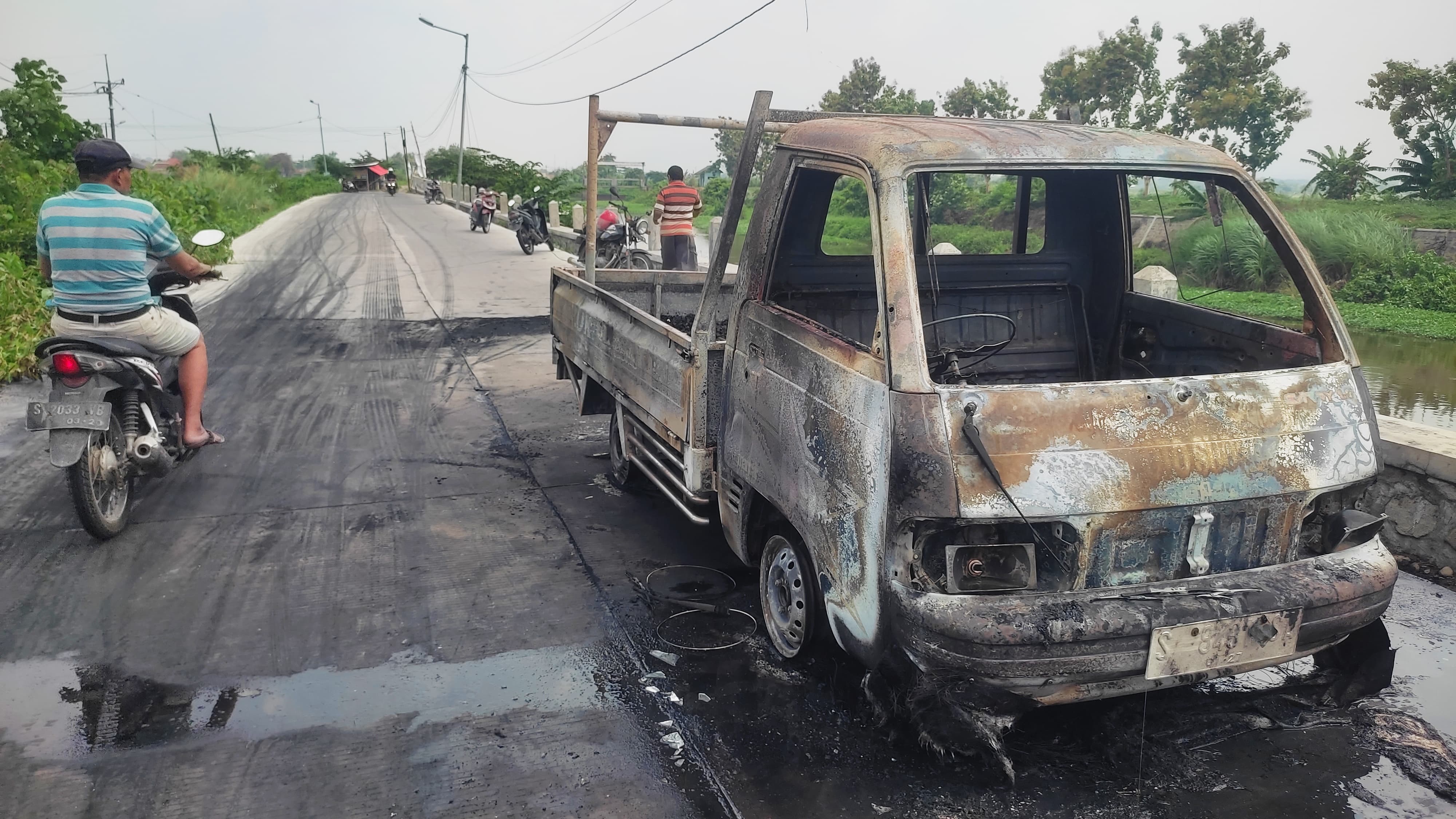 JADI TONTONAN: Peristiwa mobil pikap terbakar di Jalan Desa Kedunggempol, Kecamatan Mojosari, menjadi tontotan warga, Kamis (28/12).