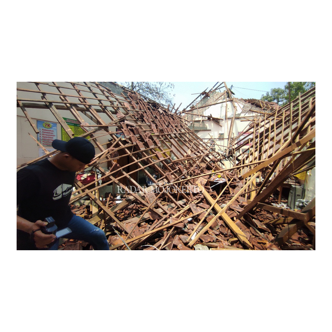 TAK KUAT: Penjaga sekolah SDN Ngingasrembyong menunjukkan lokasi bangunan yang roboh usai diterjang hujan deras dan angin kencang, Jumat (22/12).