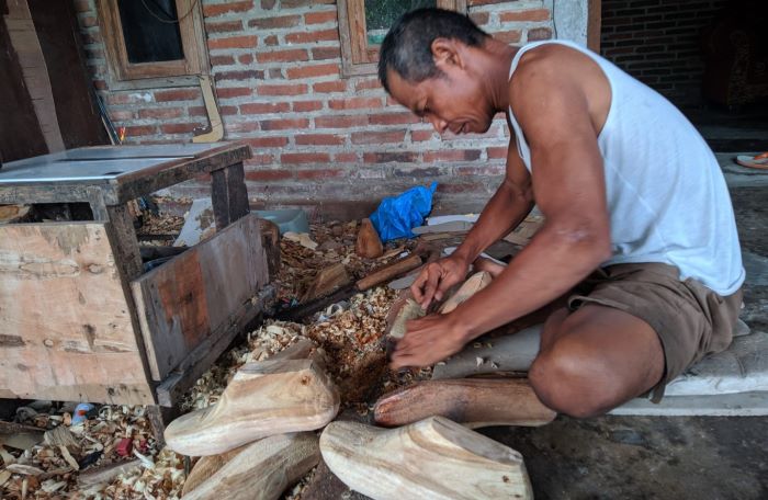 TELATEN: Mujiono mengerjakan klebut berbahan kayu, di rumahnhya, di Kelurahan Blooto, Kecamatan Prajurit Kulon, Kota Mojokerto. (foto: Afi Azizah for Radar Mojokerto)
