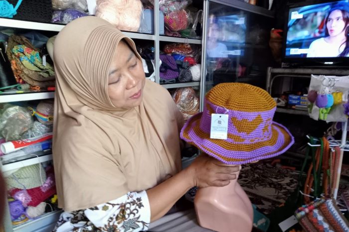 KREATIF: Nur Sutrami mengerjakan produk rajutan di rumahnya, di Jalan Empunala, Kelurahan Balongsari, Kecamatan Magersari, Kabupaten Mojokerto. (foto Putri Fadiyah for Radar Mojokerto )