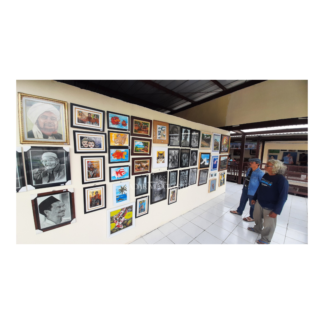 SENI RUPA: Pengunjung saat melihat karya lukis yang dipajang pada bursa lukisan murah di Pasar Seni, Rest Area Gunung Gedangan, Kota Mojokerto, Minggu (7/1).