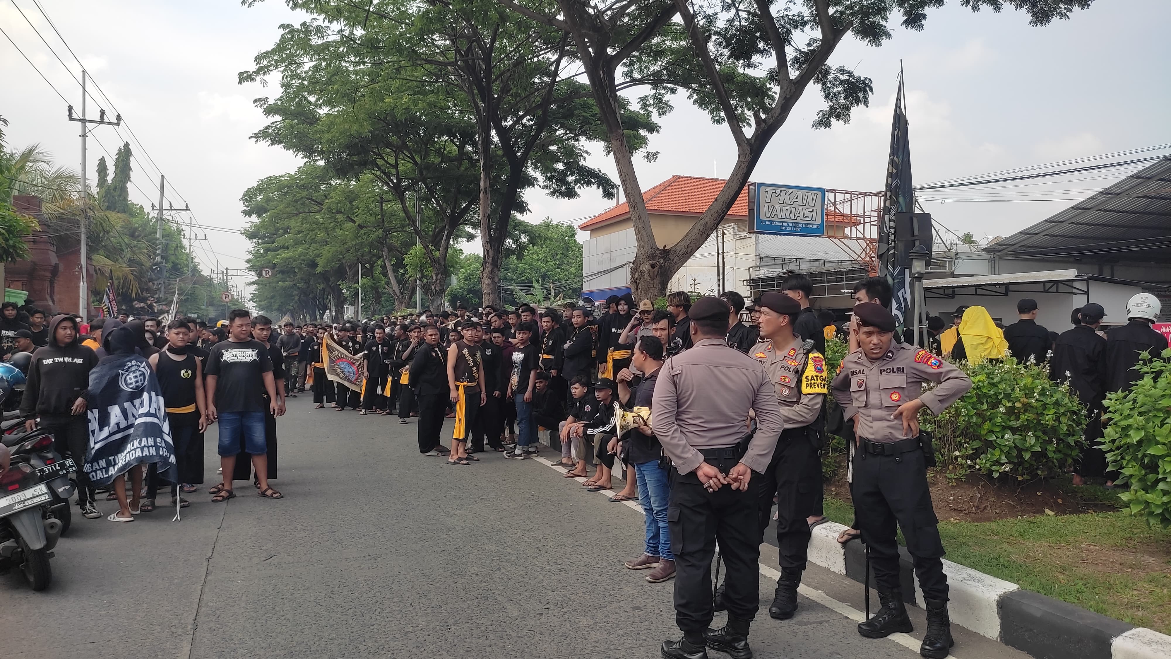 TUTUP JALAN: Massa perguruan silat PSHW yang meluruk kantor Pengadilan Negeri Mojokerto menutup ruas Jalan RA Basuni Sooko, Rabu (10/1) pagi.