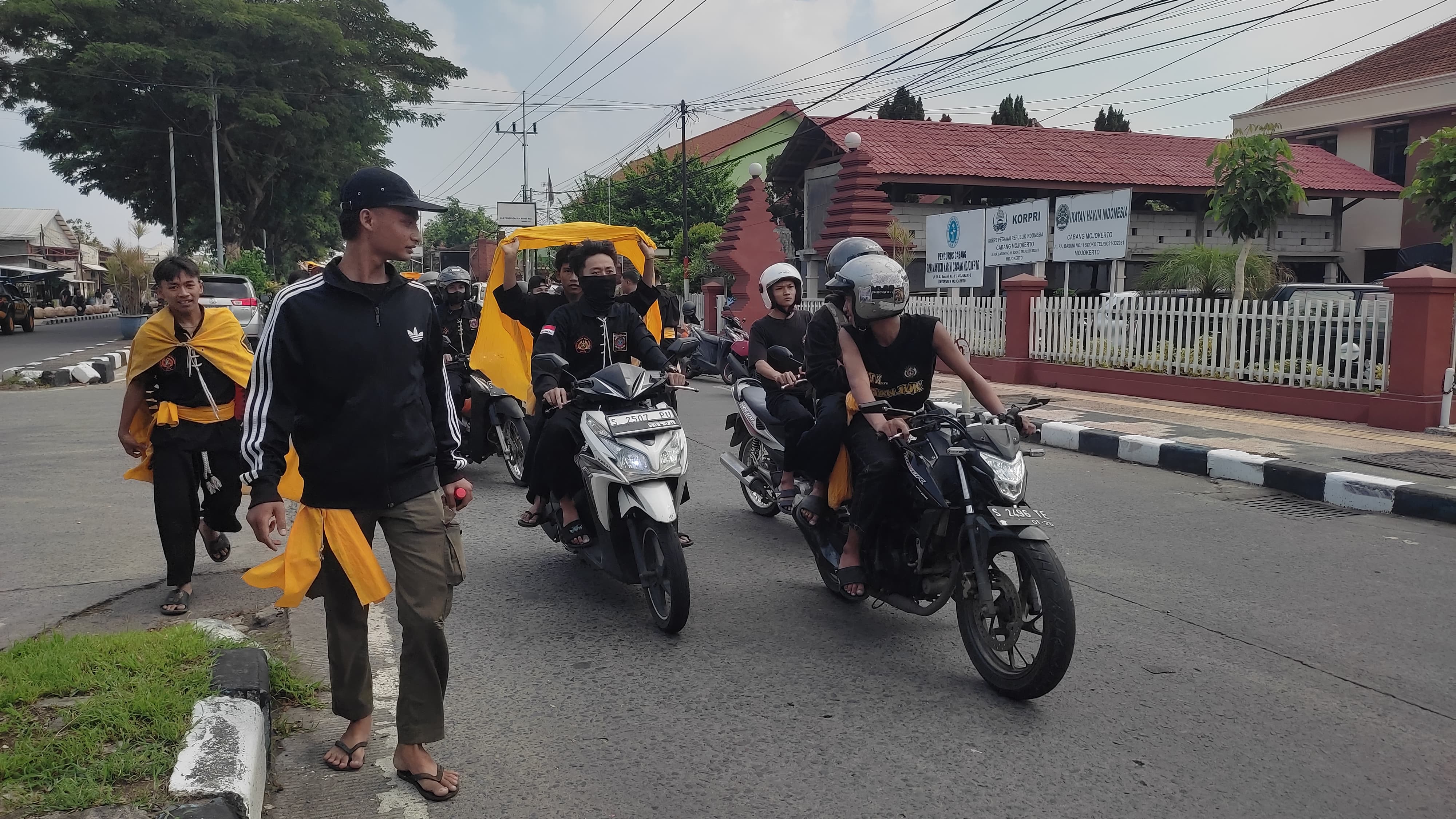 TUTUP JALAN: Massa perguruan silat PSHW yang meluruk kantor Pengadilan Negeri Mojokerto menutup ruas Jalan RA Basuni Sooko, Rabu (10/1) pagi.