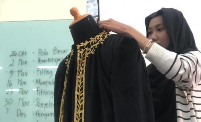 MENGHIAS: Nida Aliyah menempelkan aksen border ke baju pengantin pria untuk menambahkan kesan elegan (foto: Nida dok for Radar Mojokerto)