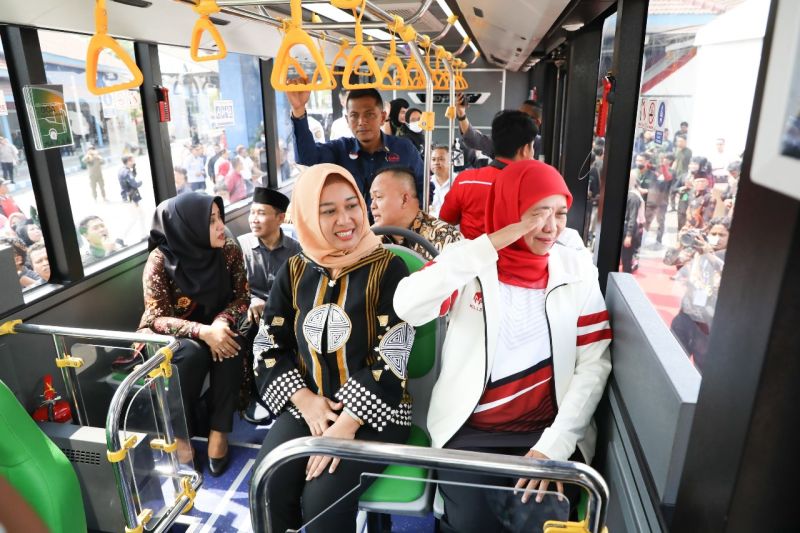 Gubernur Jawa Timur Khofifah Indar Parawansa (kanan) menyapa warga saat mencoba pelayanan Bus Trans Jatim.
