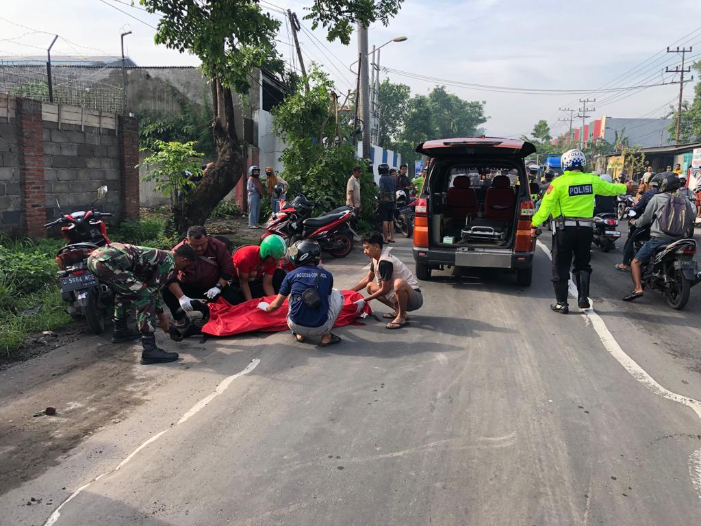 DIEVAKUASI: Petugas mengevakuasi jasad korban yang terlindas truk kontainer di Jalan Pemuda, Desa Randubango, Kecamatan Mojosari, Jumat (12/1).&nbsp;