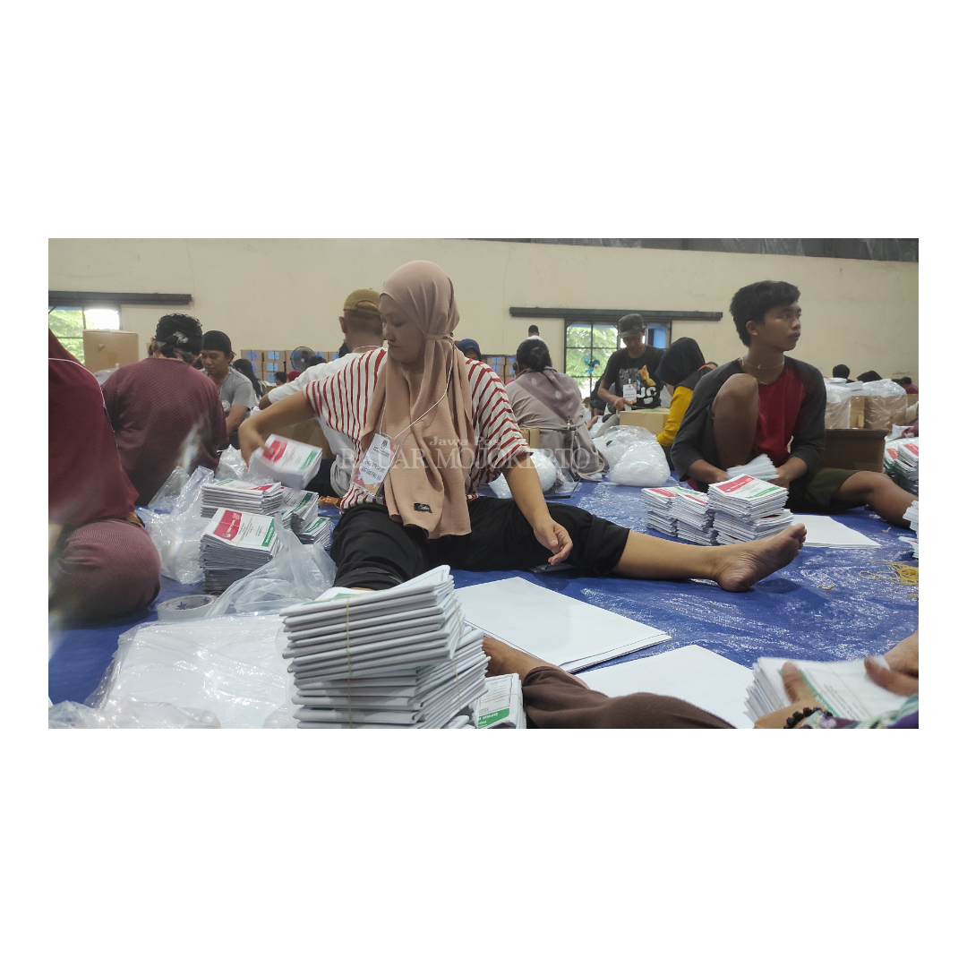 STERIL: Pekerja sibuk menyortir dan melipat surat suara Pemilu di Gudang Logistik KPU, komplek gudang Bulog, Jalan RA. Basuni, Sooko.
