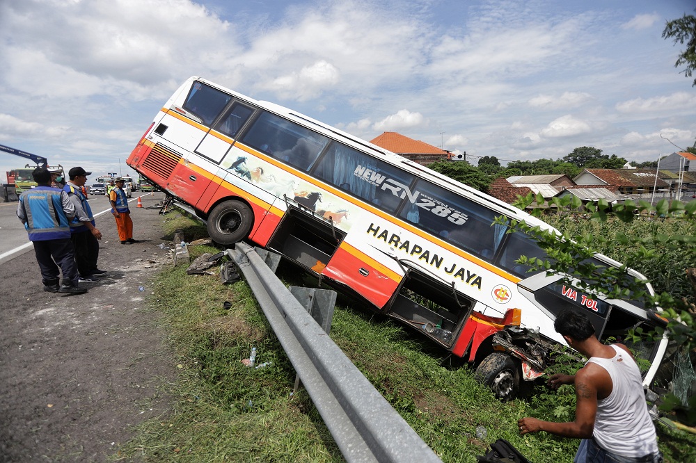 LAKA: Kondisi Bus Harapan Jaya yang nyungsep dik KM 719 tol Surabaya-Mojokerto, kemarin. Tidak ada korban jiwa dalam kecelakaan tersebut.