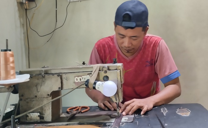 PRODUKTIF: Karyawan menjahit bagian tas, di Desa Kedungmaling, Kecamatan Sooko, Kabupaten Mojokerto. (foto: Nadya Azzahra for Radar Mojokerto)