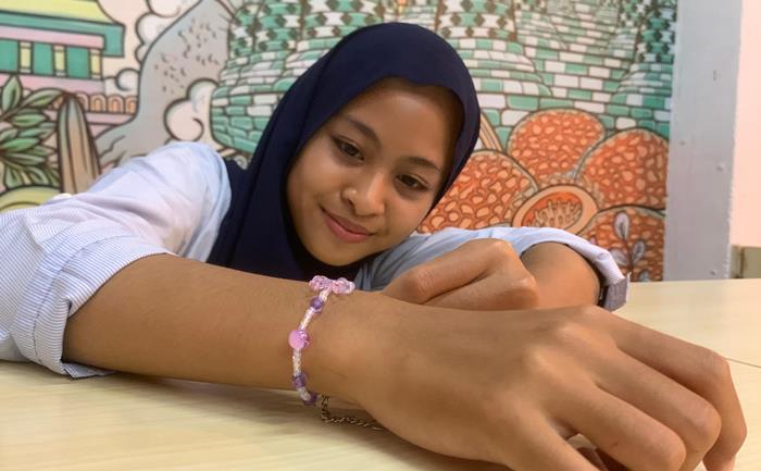 ESTETIK: Yeni Trihapsah, remaja penggemar aksesori, mengamati gelang manik karya Aulia Rahmadhani. (foto: Moch. Chariris)