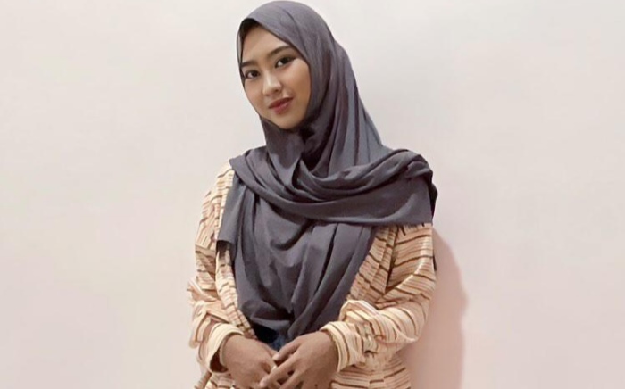 MINIMALIS: Desainer muda, Zhalfaur Rihadah, mengenakan kardigan stripe sebagai outer dipadukan dengan rok line-A. (foto: Zhalfaur Rihadah for Radar Mojokerto)
