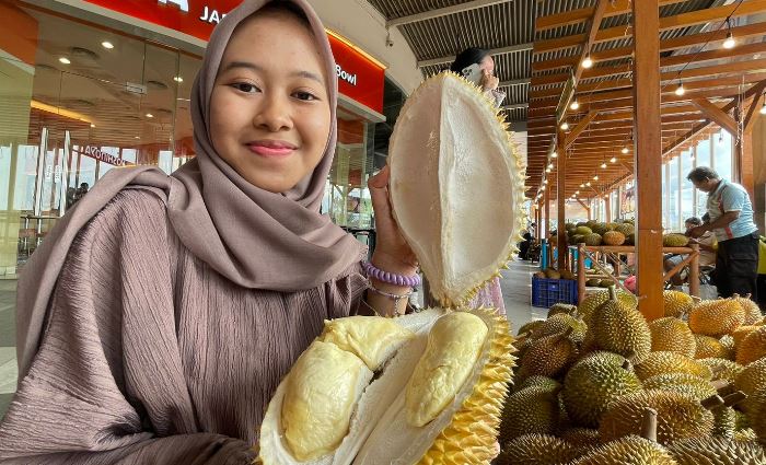 PECAH DURIAN: Pengunjung menunjukkan durian jenis lokal yang dibelinya, di festival Kenduren di Sunrise Mall Mojokerto. (foto: Moch. Chariris)