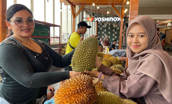 BANYAK DIMINATI: Penjual menunjukkan durian jenis bajul kepada pengunjung festival Kenduren di Sunrise Mall Mojokerto. (foto: Moch. Chariris).