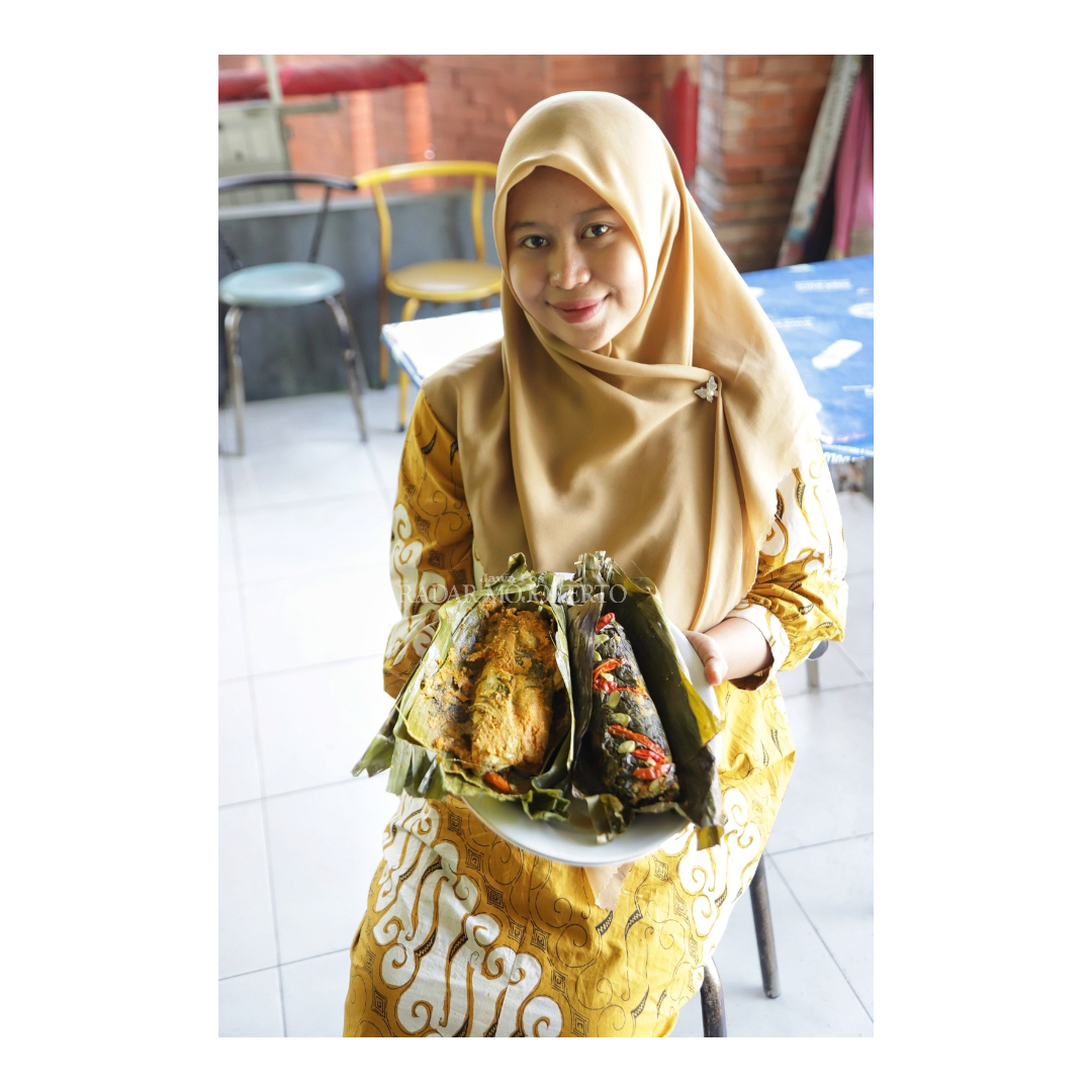 Seorang model menunjukkan kuliner pepes.