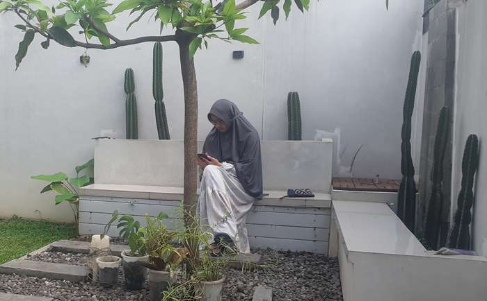 HOBI: Ruli Arini, ibu rumah tangga asal Mojokerto duduk di halaman rumahnya berhias kaktus koboi. (foto: Ruli Arini dok for Radar Mojokerto)