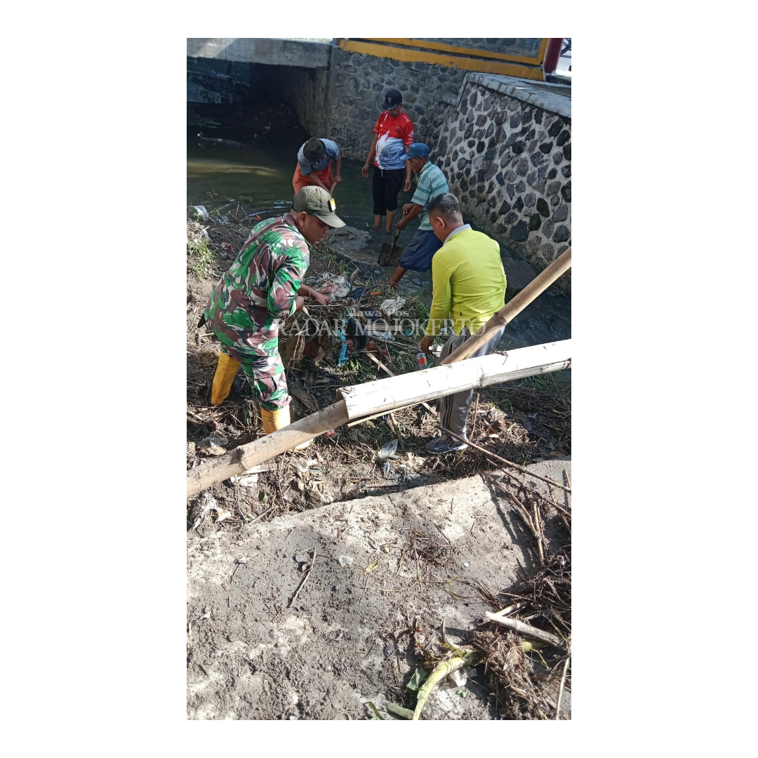 GOTONG ROYONG: Warga Desa Jetis, Kecamatan Jetis, Kabupaten Mojokerto membersihkan sampah yang menyumbat saluran air dan menyebabkan banjir luapan.