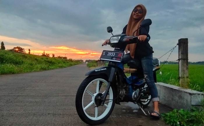 BERGAYA RETRO: Yunitha Seftiani, remaja asal Desa Karang Kedawang, Kecamatan Sooko, berpose di atas motor bebek modifikasi. (foto: Muhammad Andriyani dok for Radar Mojokerto)