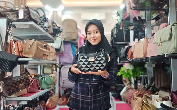 SOFT: Pengunjung menunjukkan shoulder bag di toko tas wanita, di Kelurahan Mentikan, Kecamatan Prajurit Kulon, Kota Mojokerto. (foto: Satria Putra for Radar Mojokerto)