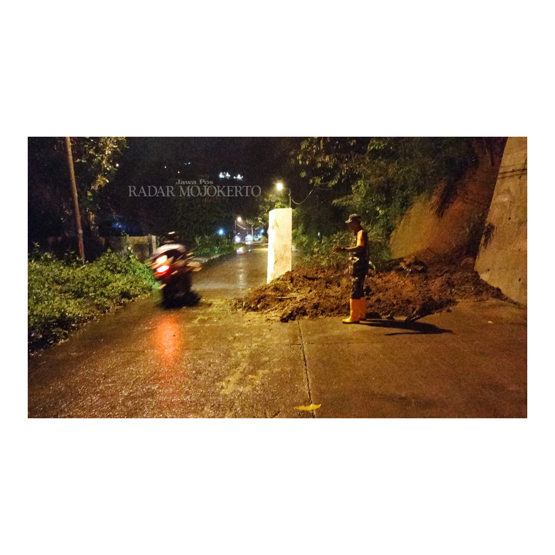 PENANGANAN: Petugas gabungan membersihkan material longsor yang menutup ruas Jalan Pacet-Trawas di Dusun Mligi, Desa Claket, Kecamatan Pacet, Selasa (6/2) malam.