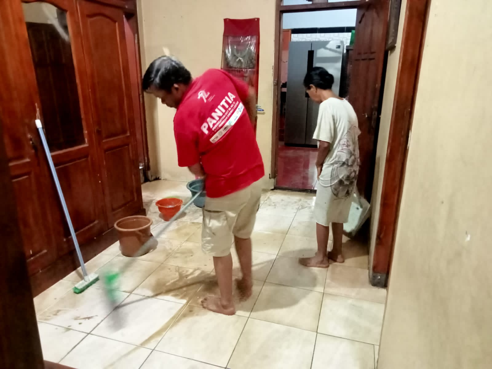 BERSIH-BERSIH: Keluarga Yuni tengah membersihkan sisa banjir di rumahnya, Desa Kupang, Kecamatan Jetis, Jumat (9/2) sore.