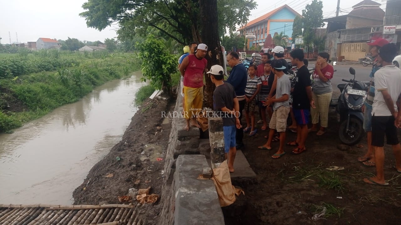 LOKASI: Warga menyemut di lokasi kejadian bocah tenggelam di Kali Anyar, depan Balai Desa Jetis, Kecamatan Jetis, Kabupaten Mojokerto, Sabtu (10/2).
