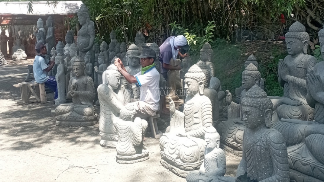 TAK DIMINATI: Sejumlah perajin patung tengah merampungkan kerajinan patung berbahan batu andesit di Dusun Jatisumber, Desa Watesumpak, Kecamatan Trowulan, Kabupaten Mojokerto, kemarin (12/2).