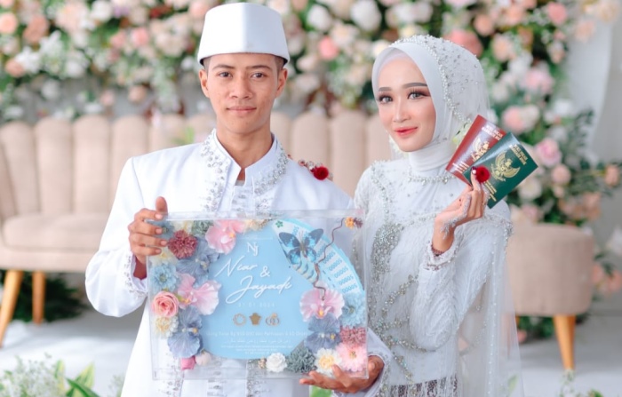 KEKINIAN: Pengantin baru, Niar Ravita dan suami Jayadi, asal Desa Jampirogo, Kecamatan Sooko, menunjukkan mahar akrilik di acara pernikahannya. (foto: dok Niar Ravita for Radar Mojokerto)