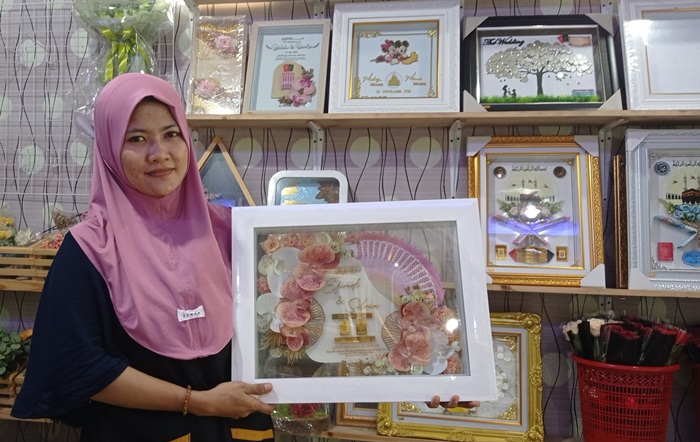 BANYAK DIBURU: Sri Ufami menunjukkan mahar akrilik berhias bunga anggrek di galerinya, Desa Wonorejo, Kecamatan Trowulan, Kabupaten Mojokerto. (foto: Wilda Mifta for Radar Mojokerto)