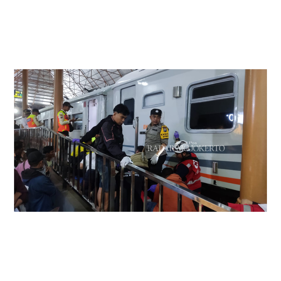 KESULITAN: Relawan mengevakuasi jasad korban yang menabrakkan diri ke kereta api komuterline Rapih Dhoho di stasiun Mojokerto, Kamis (29/2).