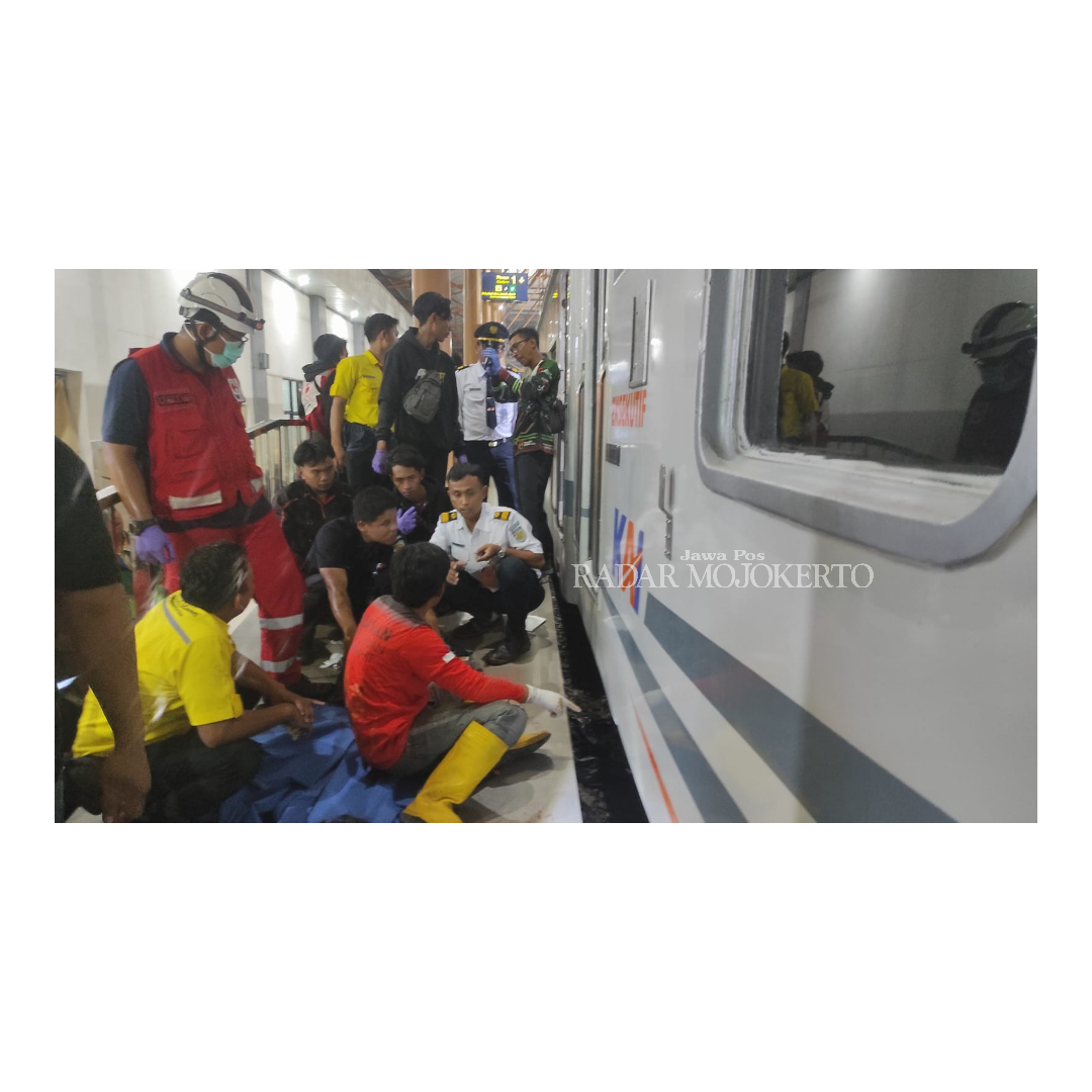 TERJEBAK: Relawan mengevakuasi jasad korban yang menabrakkan diri ke kereta api komuterline Rapih Dhoho di stasiun Mojokerto, Kamis (29/2).