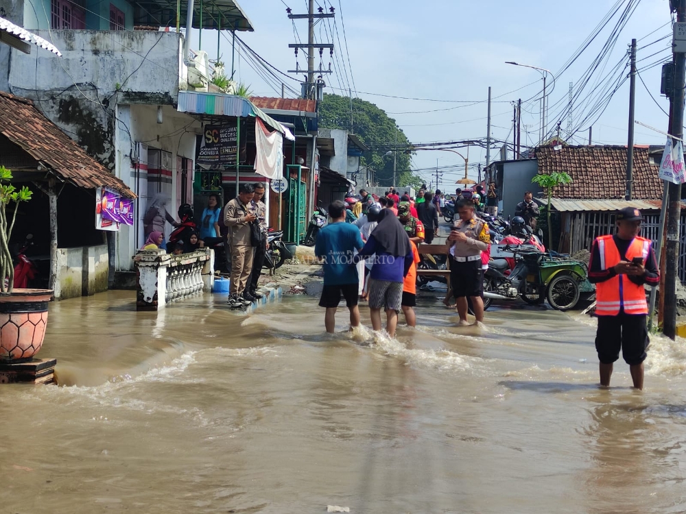 DITUTUP: Jalan Raya Meri yang tergenang banjir ditutup oleh warga dibantu kepolisian, Rabu (6/3/2024).