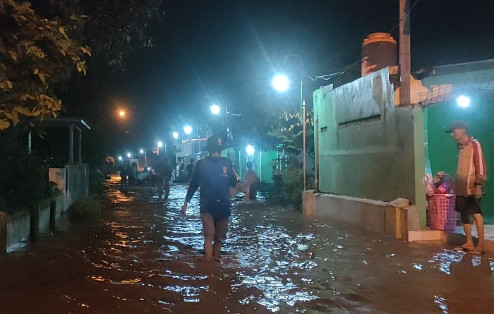 MELUBER: Personel Tagana melintasi kawasan terdampak banjir akibat tanggul Sungai Brangkal jebol di Desa Wringinrejo, Kecamatan Sooko, Sabtu (9/3) malam. (foto: Misbakhul Ulum for Radar Mojokerto)