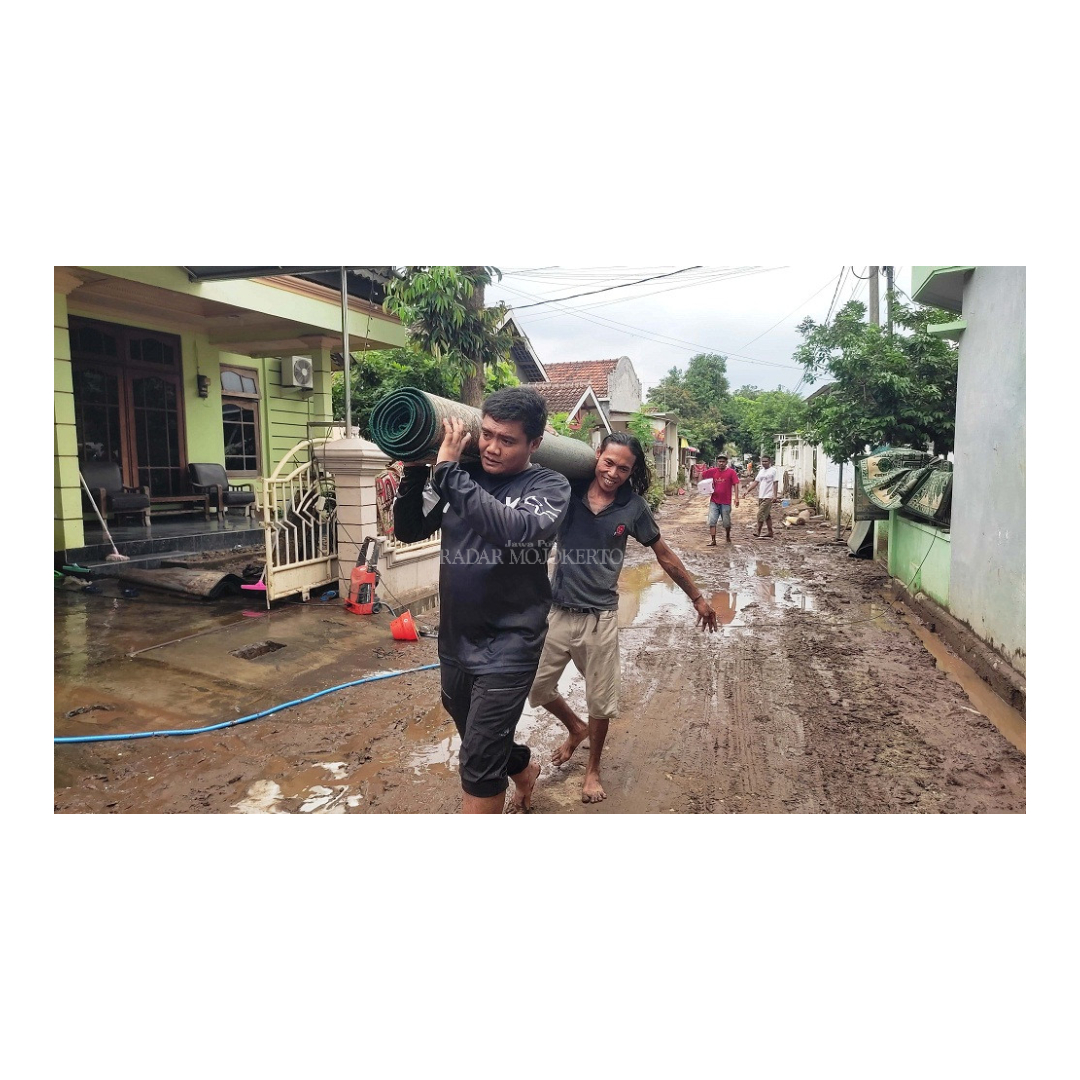 GOTONG ROYONG: Warga Dusun Sambirejo, Desa Wringinrejo, Kecamatan Sooko, berjibaku menggotong karpet musala yang baru saja dicuci usai diterjang banjir, Senin (11/3).