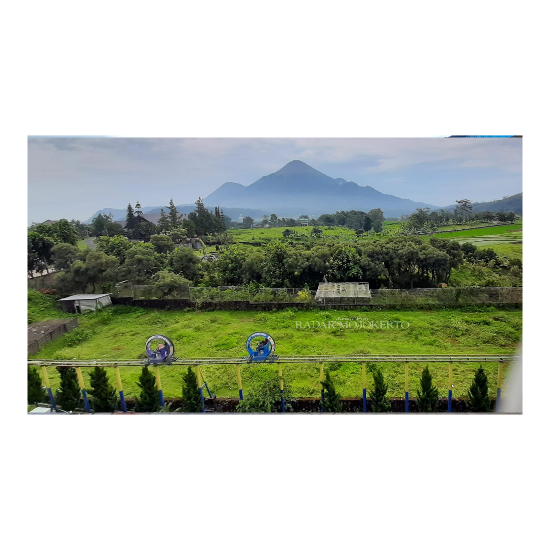 PANORAMA INDAH: Pengunjung sedang menikmati wahana sepeda udara dengan latar Gunung Penanggungan di Taman Ghanjaran, Desa Ketapanrame, Kecamatan Trawas, Kabupaten Mojokerto.