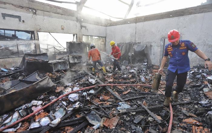 HANGUS: Anggota Satpol PP Kota Mojokerto dan tim relawan membantu proses pemadaman ruangan di RS Gatoel Kota Mojokerto yang terbakar. (foto: Sofan Kurniawan)