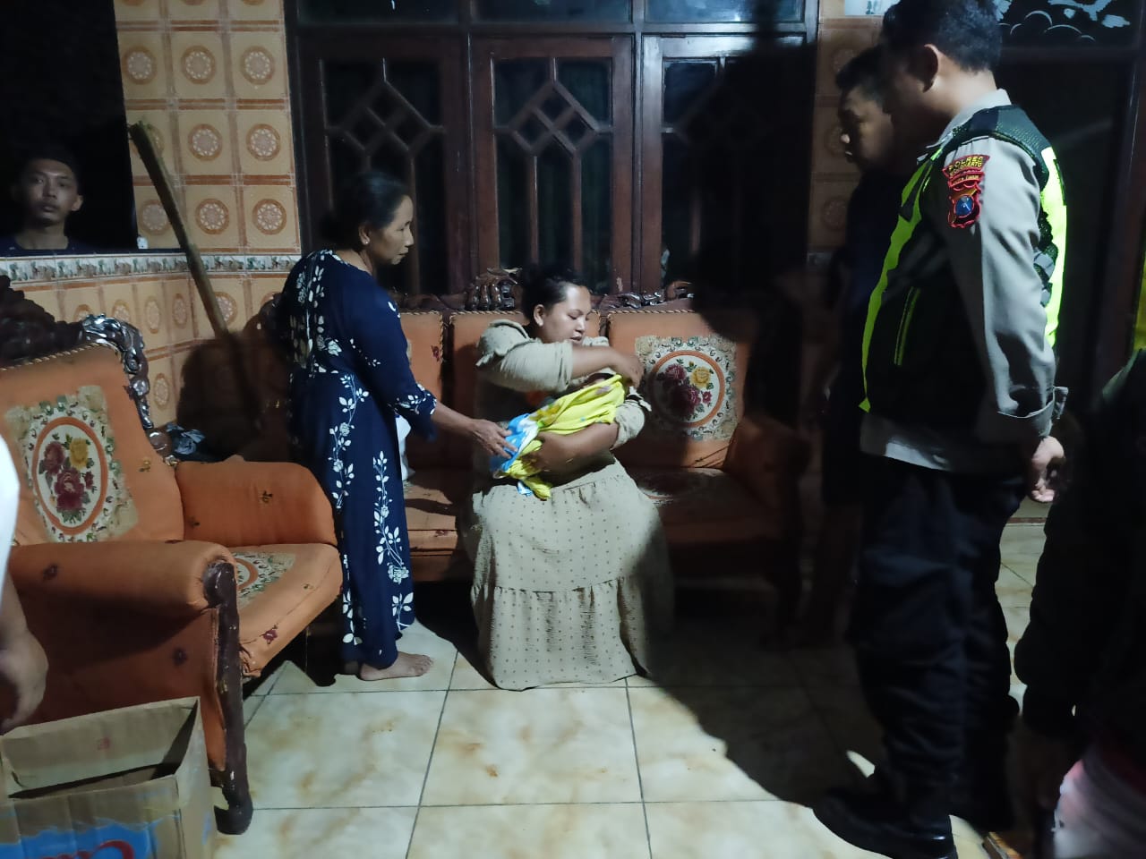 IBA: Bidan desa merawat bayi laki-laki yang ditelantarkan di teras rumah warga Desa Purworejo, Kecamatan Pungging, Kabupaten Mojokerto, Jumat (22/3).