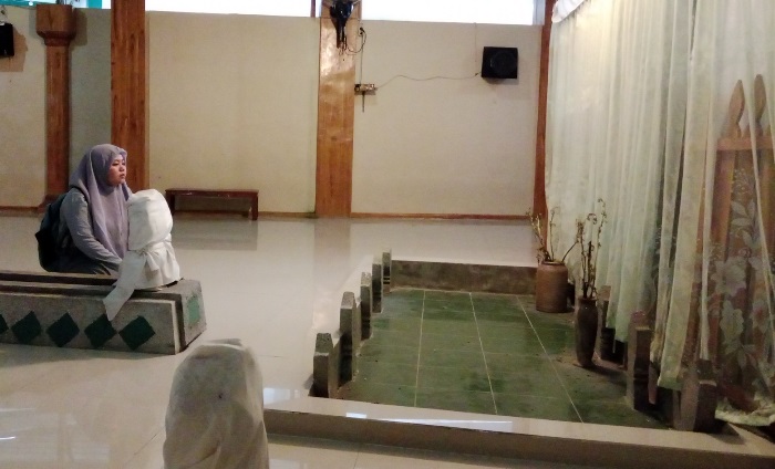 BERZIARAH: Peziarah sedang berdoa di kompleks pemakaman muassis Pondok Pesantren As-Sholichiyah di Penarip Gang 2, Kelurahan/Kecamatan Kranggan, Kota Mojokerto. (foto: Bryan Noer for Radar Mojokerto)