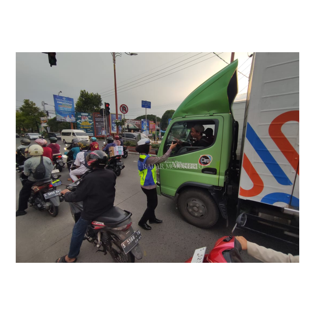 PEDULI: Anggota Satlantas Polres Mojokerto Kota membagikan takjil gratis ke pengguna jalan dan penjaga palang pintu di jalan Pahlawan Kota Mojokerto kemarin.