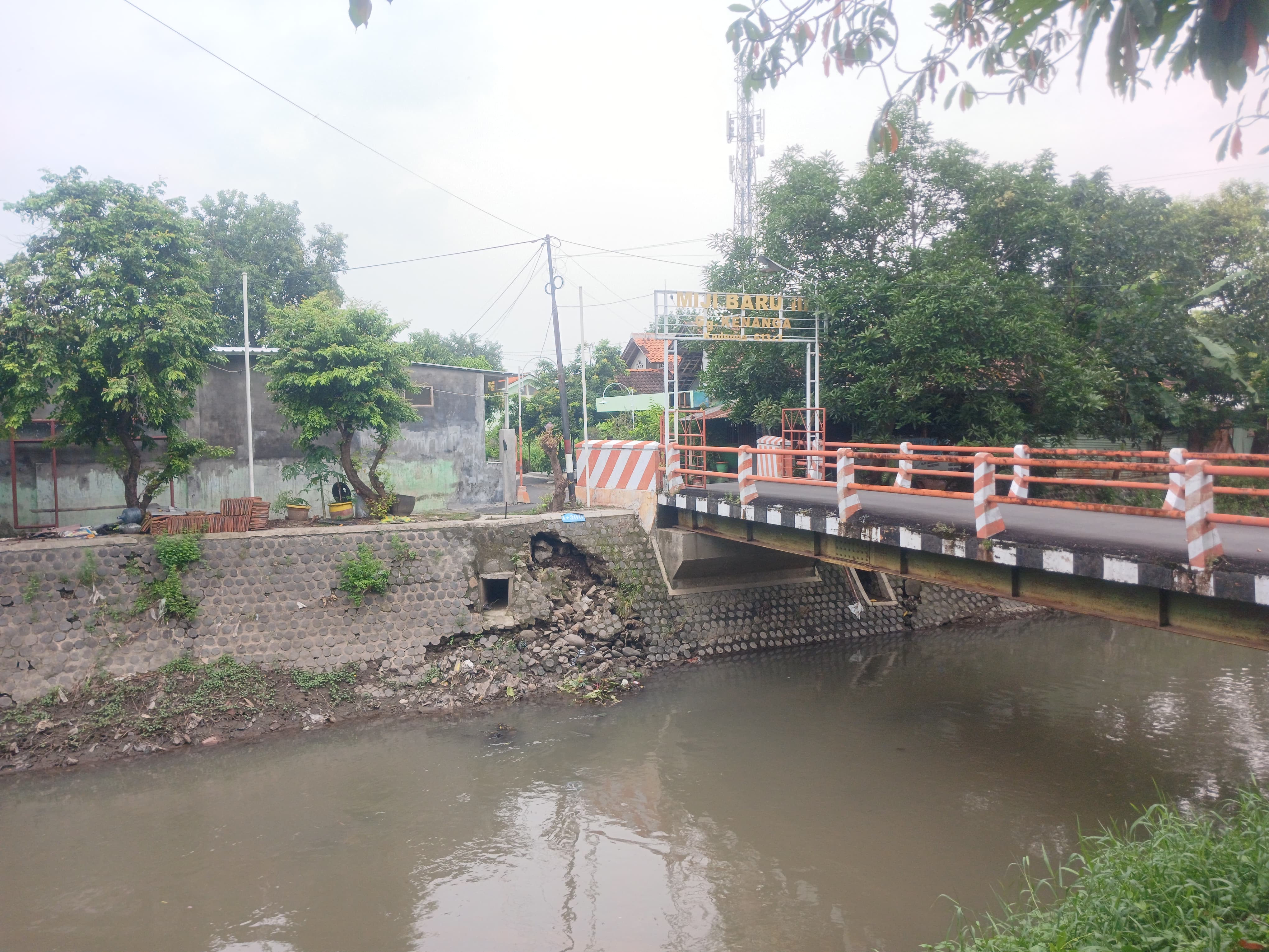 BAHAYA: Kondisi tanggul sungai di Jalan Tropodo dekat rumah dan jembatan Gang Miji Baru III, Kota Mojokerto, yang tergerus aliran, kemarin.