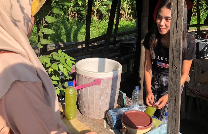 JADI PERHATIAN: Risa penjual es tebu di Jalan Bypass Mojokerto sedang menyiapkan pesanan pembeli. (foto: Bryan Noer for Radar Mojokerto).