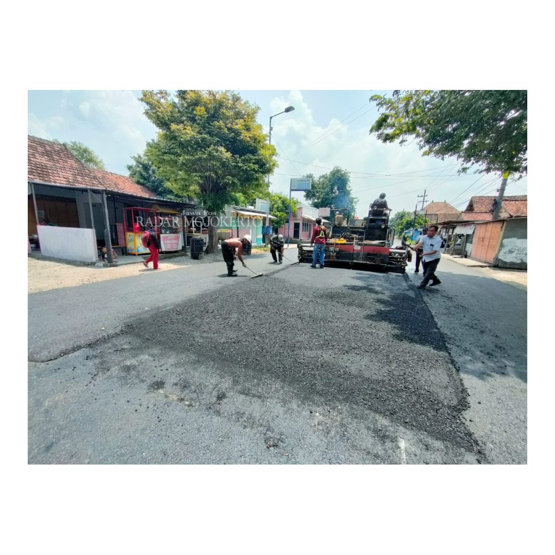 DIKEBUT: Pekerja proyek milik Dinas PUPR Kabupaten Mojokerto melakukan penghamparan dan pemadatan konstruksi aspal di ruas jalan Wringinrejo-Kedungmaling, Kecamatan Sooko.