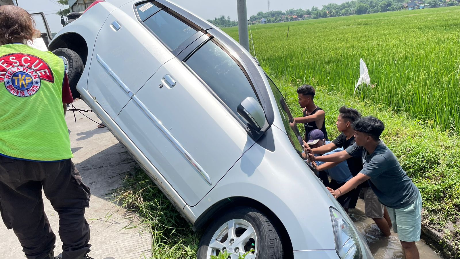 LAKA: Relawan bersama warga membantu mengevakuasi mobil yang tercebur parit di Desa Ngarjo, Kecamatan Mojoanyar, Kabupaten Mojokerto, Sabtu (6/4/2024) siang.