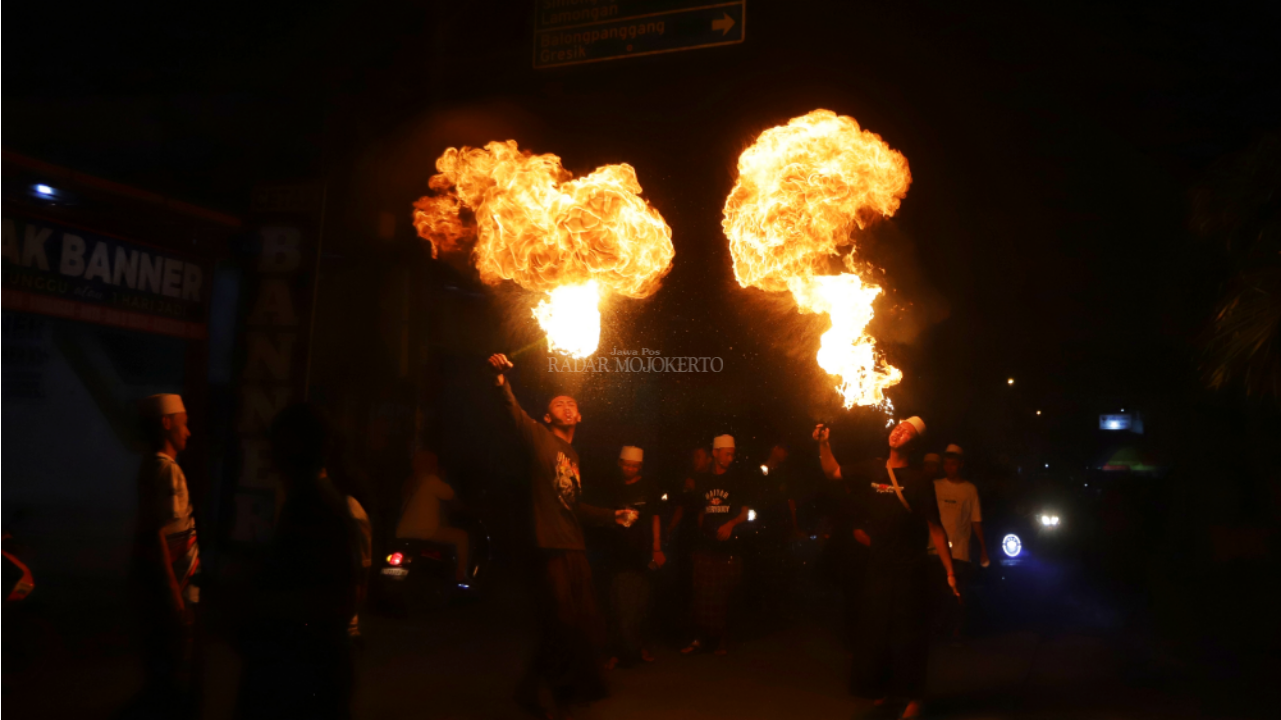 EKSPRESI: Warga Dawarblandong Kabupaten Mojokerto beratraksi ketika mengikuti pawai obor malam Idul Fitri, (9/4/2024).