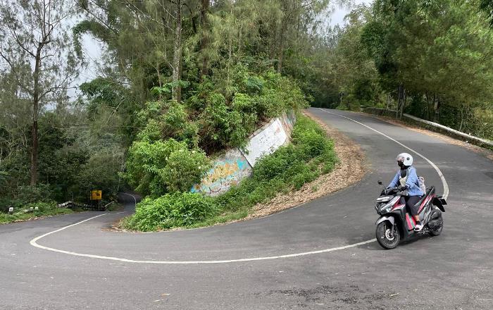 TIKUNGAN CINTA: Pemudik mengendarai sepeda motor dari arah Cangar, Batu melintasi Tikungan Gajah Mungkur, di Jalur Pacet-Cangar, Rabu (9/4). (foto: Moch. Chariris)