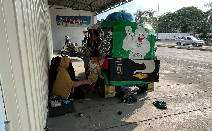 SATU KELUARGA: Pemudik asal Jakarta masih dalam satu keluarga ini harus bermalam di teras toko warga di Jalan Raya Desa Jatipasar, Kecamatan Trowulan, Mojokerto. (foto: Moch. Chariris)