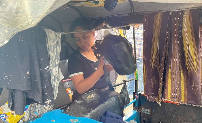 TERKENDALA: Cindia Sela mengambil barang bawan dalam bajai yang ditumpangi dari Jakarta ke Banyuwangi. (foto: Moch. Chariris)